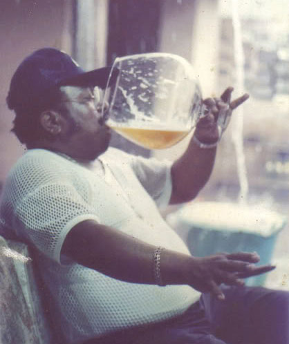 Photo d'un homme buvtant une gigantesque bière dans un verre à pied.