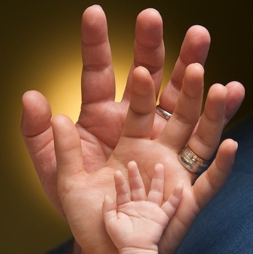 Main d'un enfant, dans la mains d'une femme dans la main d'un homme