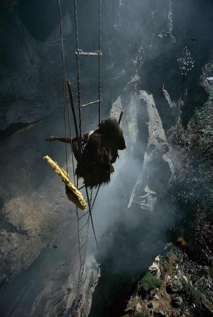 Photo d'un homme grimpant le long d'un gouffre avec une échelle rustique
