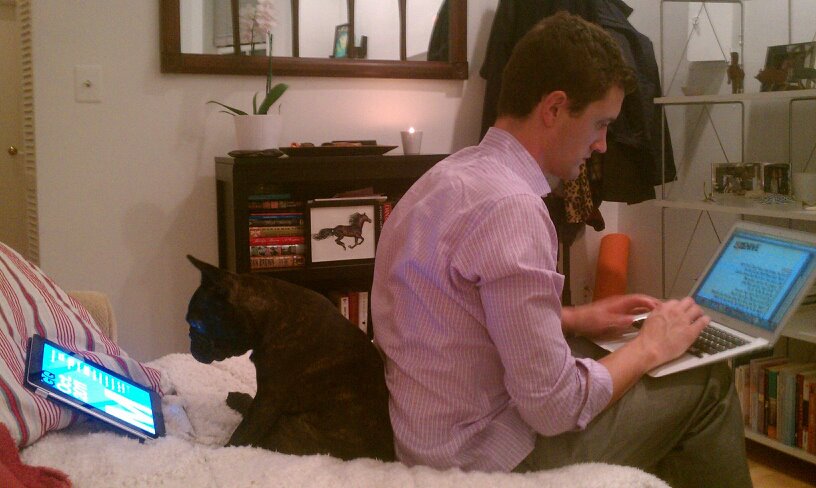 Photo d'un chien et d'un homme, consultant le Web dos à dos.