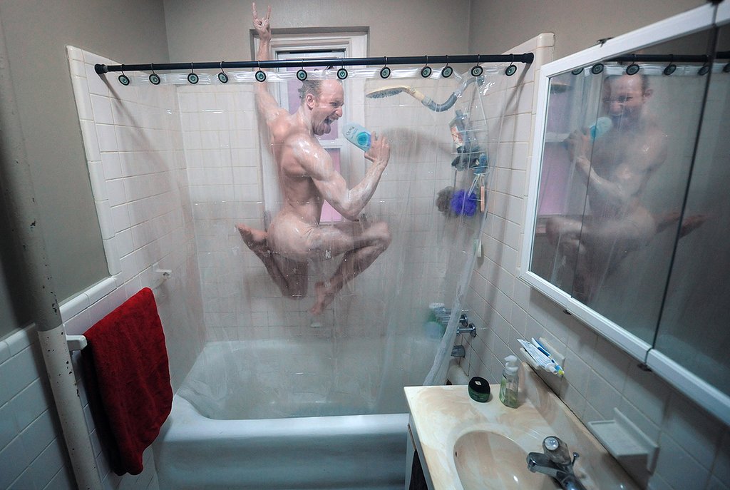 Composition où un danseur de balet effectue une figure de saut nue sous la douche